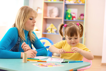 Teacher with child in preschool