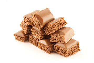 tower of pieces of porous chocolate isolated on white