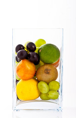 mix of various fruits in a square vase of glass