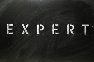 The word EXPERT in stencil letters on a blackboard