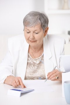 Senior woman using calculator
