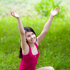 beauty girl with open hands over green grass in sunny day