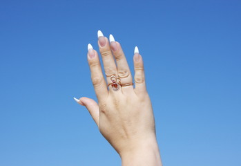 beautiful woman hand on a background blue sky