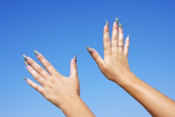 beautiful woman hands on a background blue sky