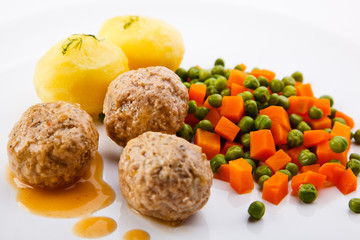 Roasted meatballs with boiled potatoes, peas and carrot