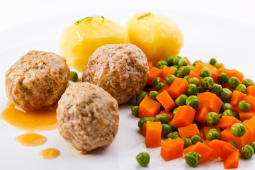 Roasted meatballs with boiled potatoes, peas and carrot