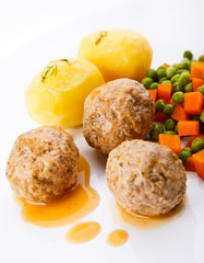 Roasted meatballs with boiled potatoes, peas and carrot
