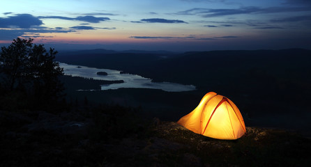 A tent lit up at dusk