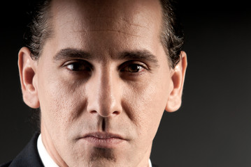 Fototapeta premium Adult businessman closeup portrait on dark background.