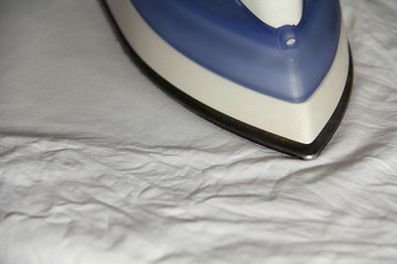 утюг гладит белую ткань