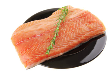 fresh raw salmon fillet on black with rosemary