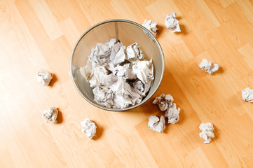 Garbage bin with paper waste isolated on white