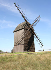Fototapeta na wymiar Antique trestle type Windmill (from 1821) in a field