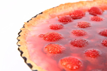 Strawberry Tart in a tart pan on a white background in close up