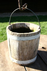 Fototapeta premium Antique wooden bucket near a well