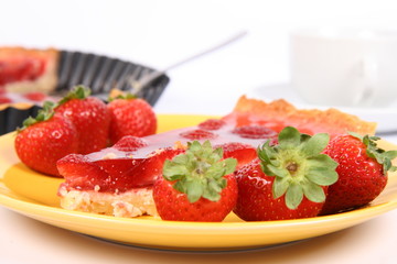 Piece of Strawberry Tart with cup of coffee and tart pan