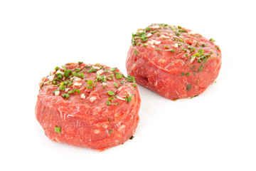 two raw German beef steak over white background