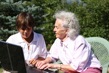 jeune garçon et femme agée utilisant un ordinateur