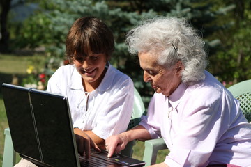 jeune gar&ccedil;on apprenant l'informatique &agrave; sa grand m&egrave;re
