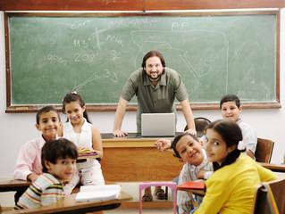 Teacher in classroom with his little happy students