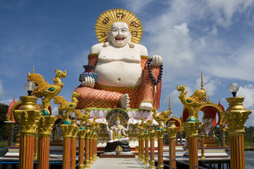 Fat laughing Buddha over blue sky, Koh Samui. Thailand