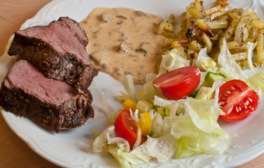 Cuts of tenderloin with sauce and tomatoes