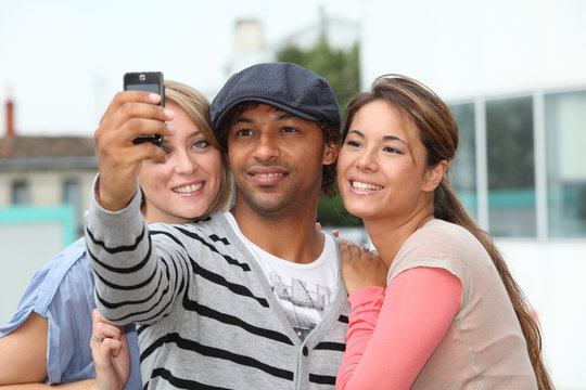 Group of friends taking picture with mobile phone