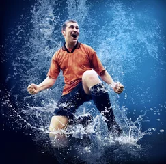Selbstklebende Fototapeten Wassertropfen um Fußballspieler unter Wasser auf blauem Hintergrund © Andrii IURLOV
