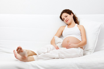 Young pregnant woman relaxing on sofa