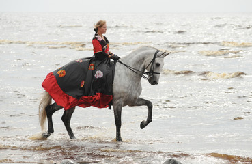 Woman riding horse in sea
