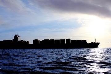 merchant ship cargo back light sea sunshine