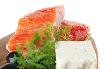 smoked salmon on wooden plate with white cheese