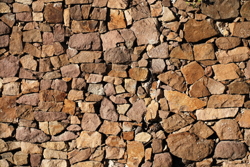 Closeup view of ocre irregular stone wall