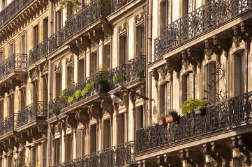Fenêtres et balcons sur la façade d'un immeuble hausmannien typique de l'architecture à Paris,...