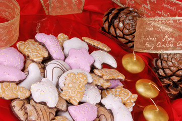 Gingerbread cookies and Christmas decorations over red backgroun