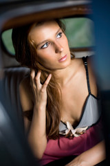 Fototapeta na wymiar Young brunette posing with vintage car