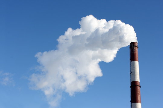 Smoking stack of thermal power station against a blue sky