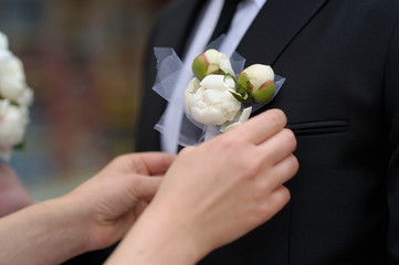 Bride adjusting groom's boutonniere