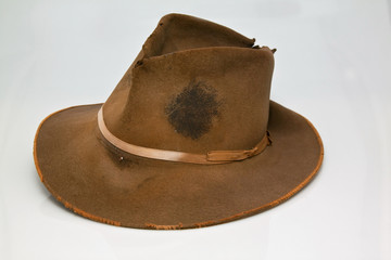 Old, worn brown hat, that is stained with sweet of hard labour