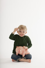 Young Boy Saving Money in a Coin Bank