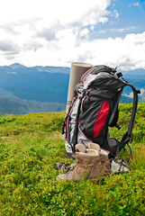 Tourists backpack and used trekking boots in mountains