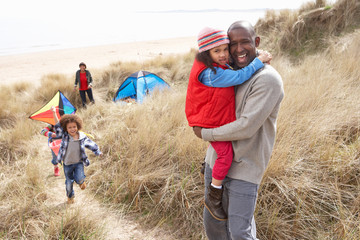 Family Having Fun With Kite In Sand Dunes