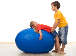 Fototapeta na wymiar Trust my sister - kids playing with large rubber ball