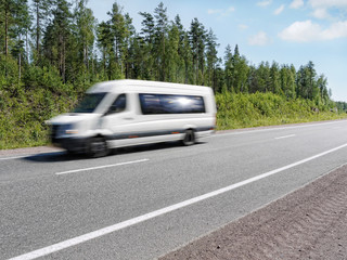 white mini bus speeding on country highway, motion blur