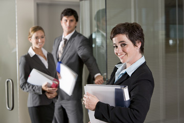 Three office workers at door of boardroom