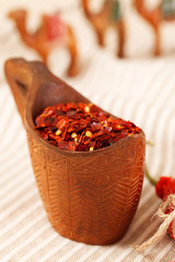 red chillies paper flakes in curved wooden bowl and camel carava