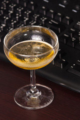 Wine glass and black keyboard on the desk