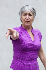 femme senior index levé  accusation  médisance