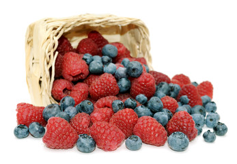 Raspberries, blueberries and wicker basket.