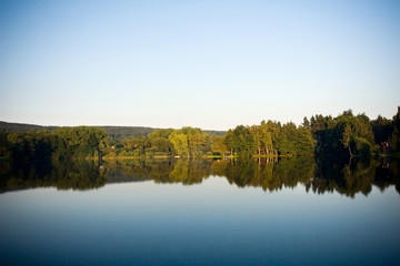 Fototapeta na wymiar Lake, forest and sky at romantic evening